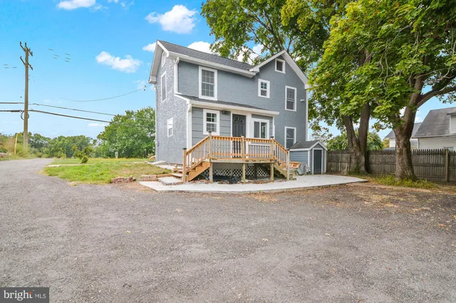 a view of a house with a yard and large tree