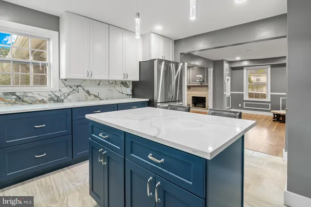 a kitchen with a table chairs refrigerator and microwave