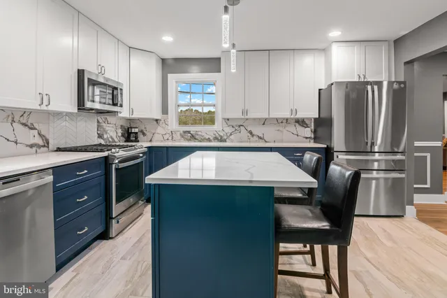 a kitchen with stainless steel appliances granite countertop a stove top oven a sink refrigerator and microwave