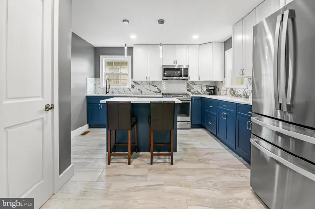 a kitchen with stainless steel appliances granite countertop a sink a stove a refrigerator and cabinets