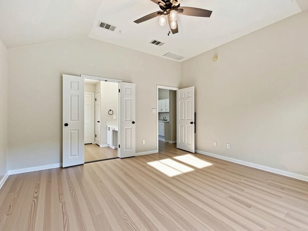 1201 Ridgewood Drive Leander, TX 78641 - Photo 15 of 28 Unfurnished bedroom featuring vaulted ceiling, a ceiling fan, and light wood-style floors