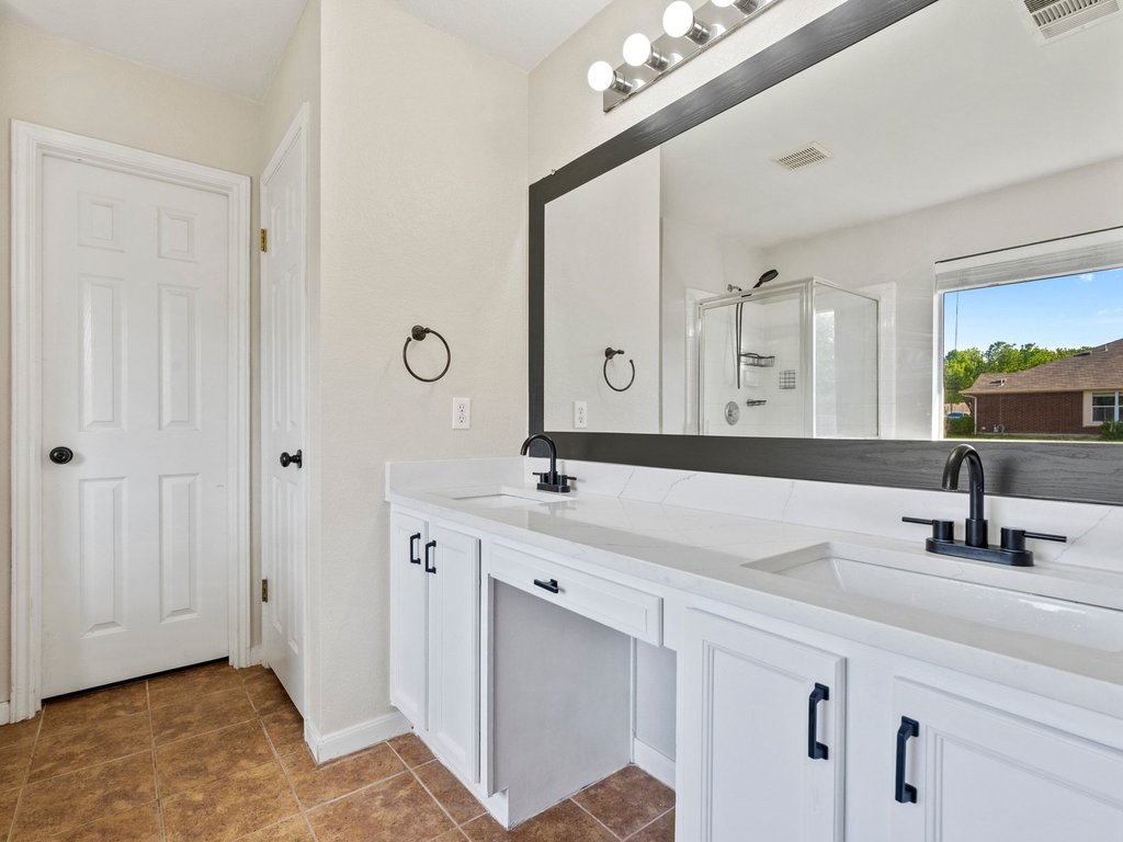 1201 Ridgewood Drive Leander, TX 78641 - Photo 16 of 28 Full bath with a stall shower, double vanity, and dark tile patterned floors