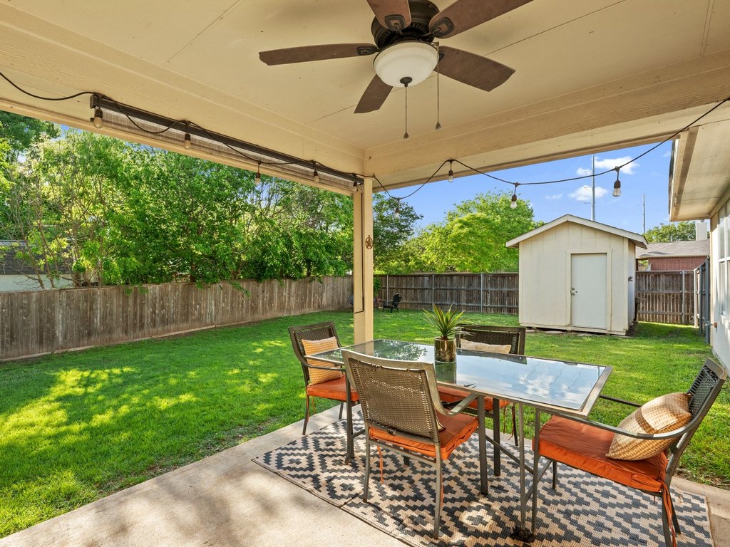 1201 Ridgewood Drive Leander, TX 78641 - Photo 24 of 28 Fenced backyard with outdoor dining area, a patio, a ceiling fan, and a shed