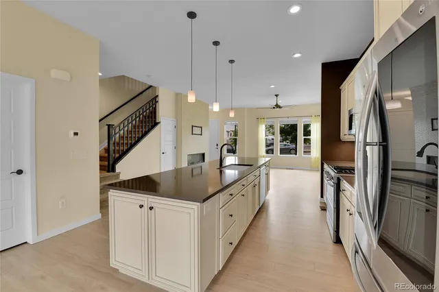 a open kitchen with stainless steel appliances granite countertop a sink and a refrigerator