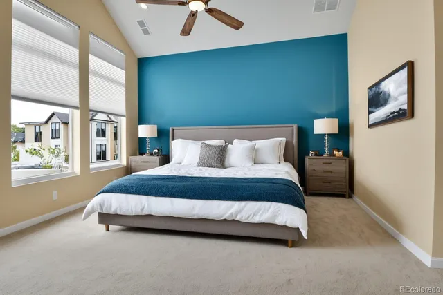 a bedroom with a bed lamp and a large window