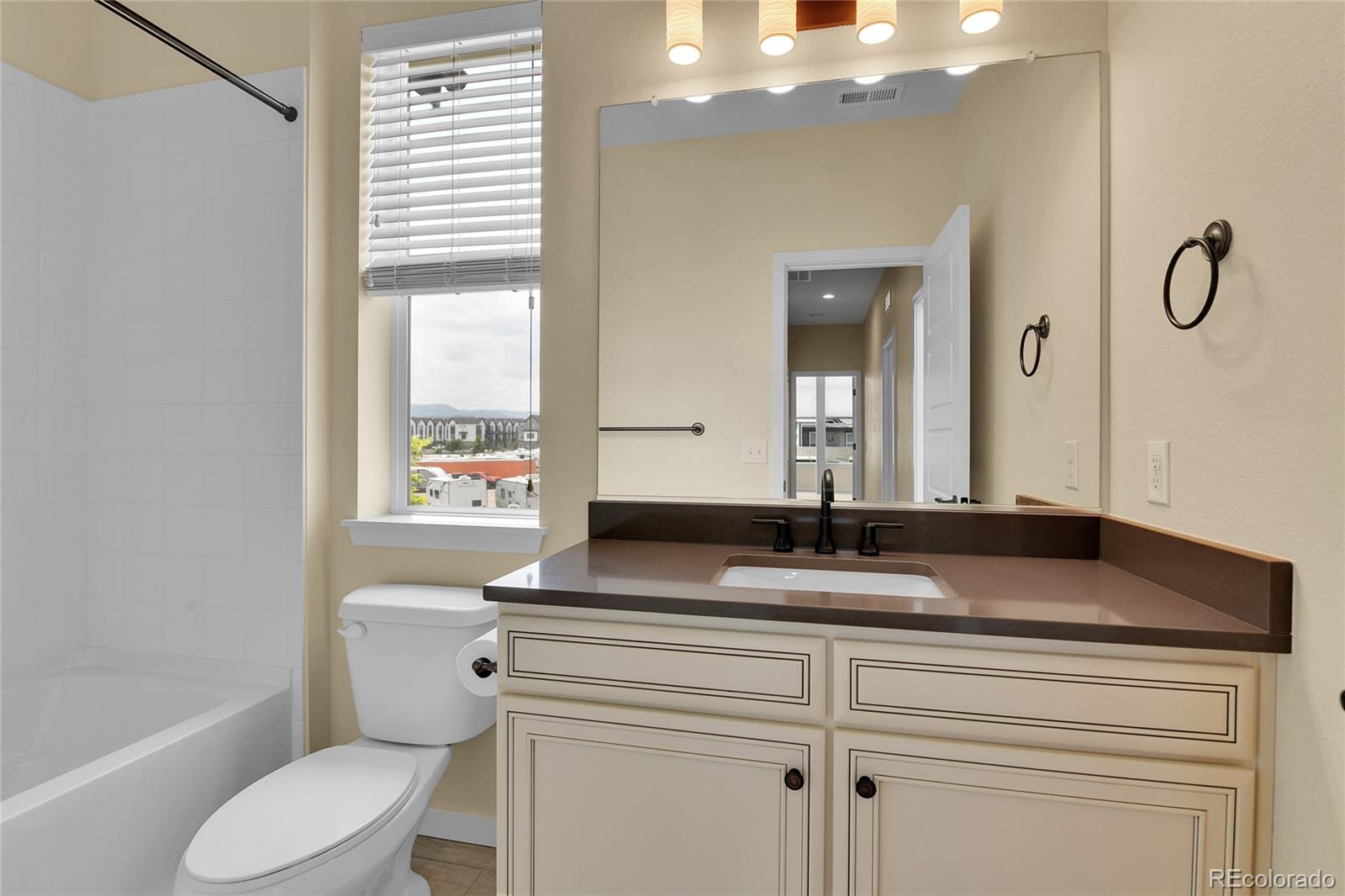 5154 Taft Court Wheat Ridge, CO 80033 - Photo 28 of 44 a bathroom with a granite countertop sink toilet and mirror