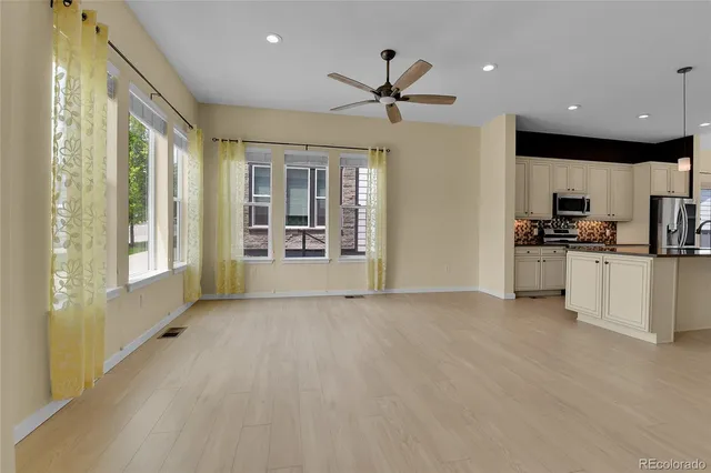 a view of a kitchen with a sink and dishwasher a refrigerator with wooden floor