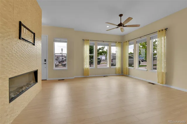 a view of an empty room with a fireplace and a window