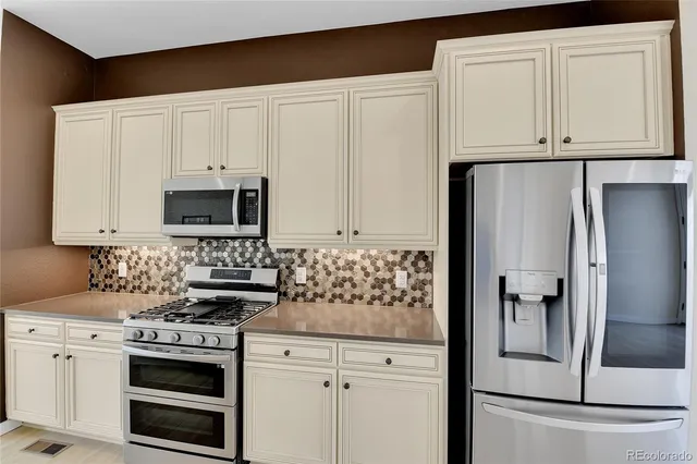 a kitchen with white cabinets and stainless steel appliances