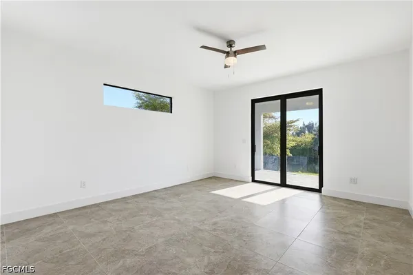 an empty room with an entryway and fan