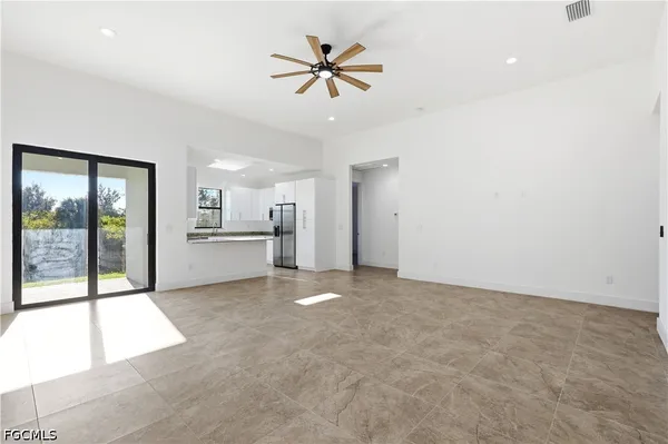 a view of an empty room with a kitchen