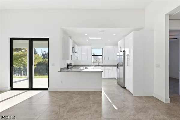 a kitchen with stainless steel appliances granite countertop a refrigerator a sink a stove a microwave and island