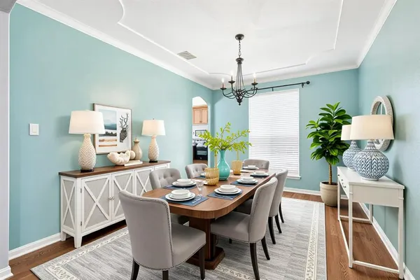 a view of a dining room with furniture wooden floor and chandelier