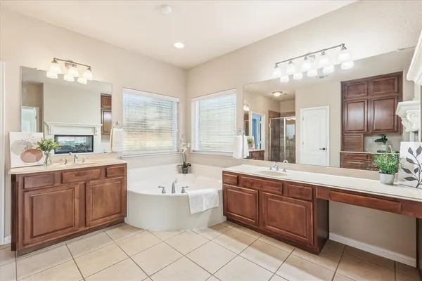 a large bathroom with a large tub sink vanity and mirror