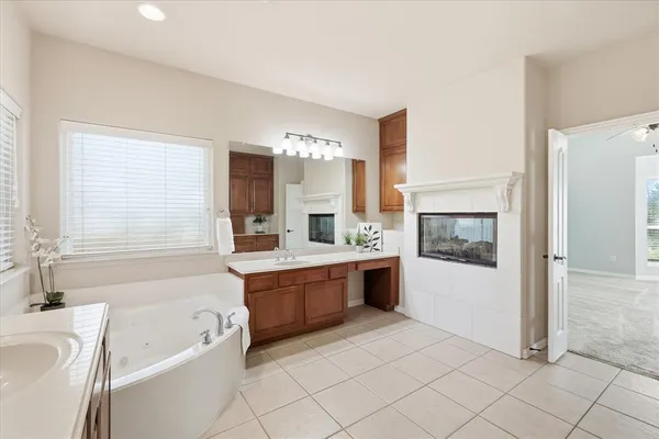 a spacious bathroom with a tub sink and mirror