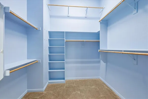 a view of walk in closet with empty racks