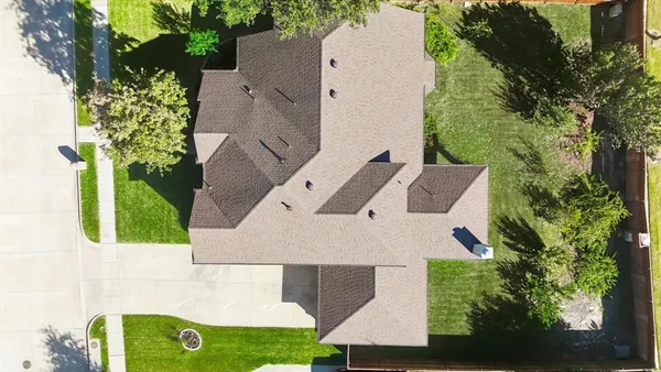 an aerial view of a house with a yard and trees
