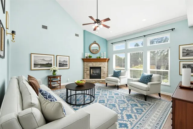 a living room with furniture a fireplace and a large window