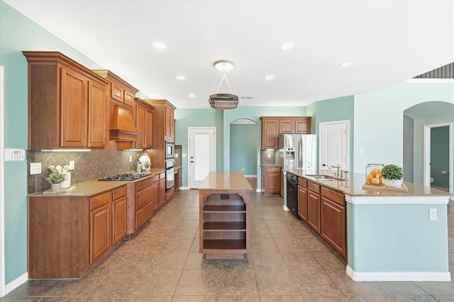 a kitchen with stainless steel appliances granite countertop a stove and a refrigerator