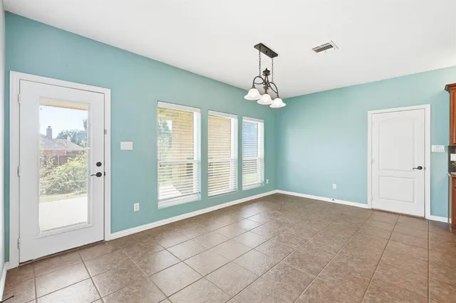 a view of an empty room with a kitchen and a fireplace