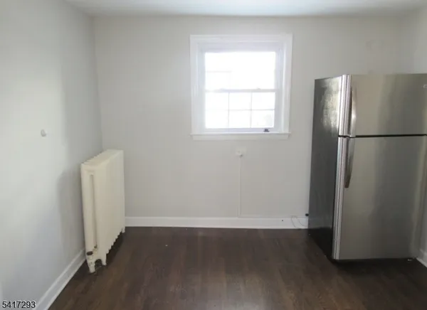 a view of a kitchen with wooden floor and a window