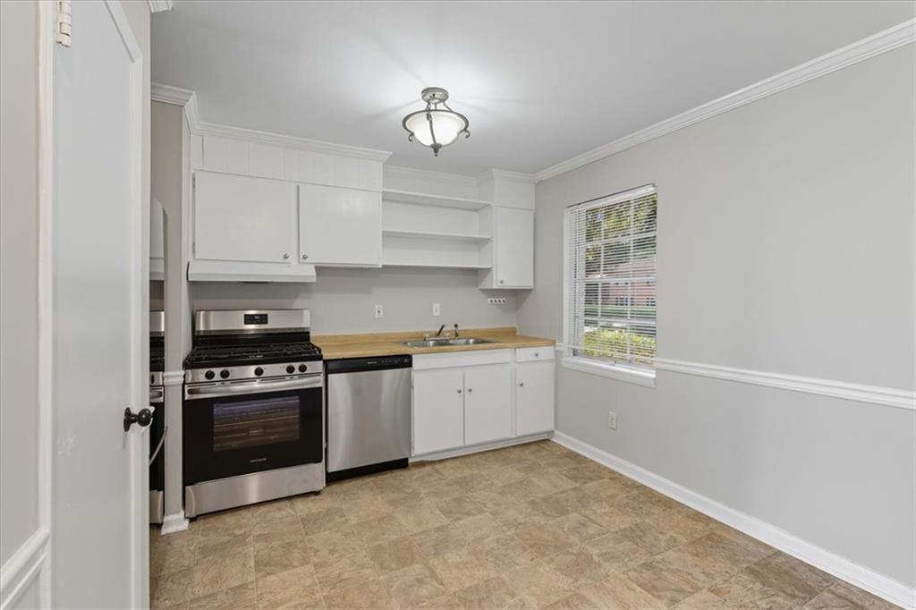 2427 Lawrenceville Highway, Unit 4B Decatur, GA 30033 - Photo 11 of 22 a kitchen with granite countertop a stove sink and cabinets