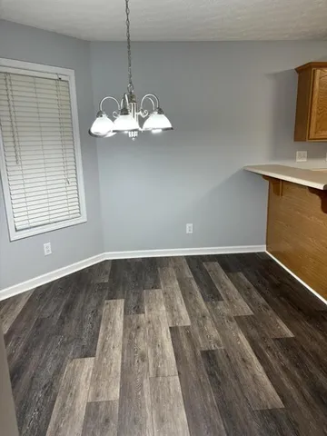 a view of a room with wooden floor and cabinets