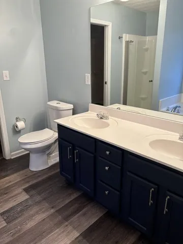 a spacious bathroom with a double vanity sink toilet and a mirror