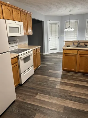 a kitchen with stainless steel appliances wooden floor sink and wooden cabinets