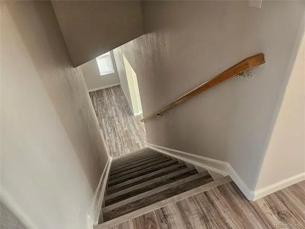 a view of staircase with white walls and railing
