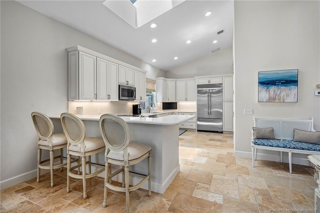 7000 Southeast Lakeview Terrace Stuart, FL 34996 - Photo 11 of 56 a kitchen with a dining table chairs and large window