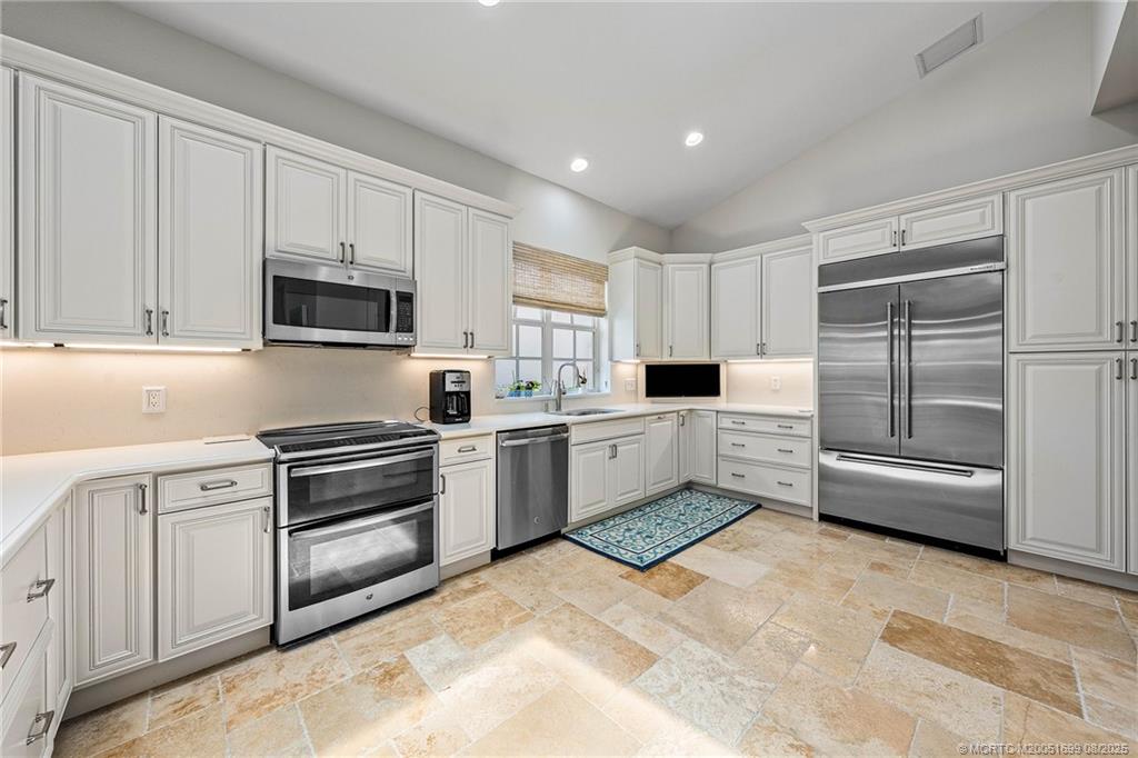 7000 Southeast Lakeview Terrace Stuart, FL 34996 - Photo 12 of 56 a kitchen with granite countertop a refrigerator sink and microwave