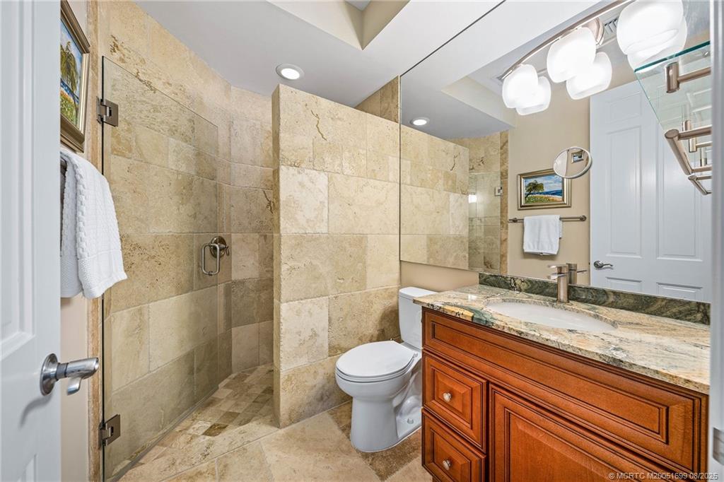 7000 Southeast Lakeview Terrace Stuart, FL 34996 - Photo 32 of 56 a bathroom with a granite countertop sink a toilet and shower