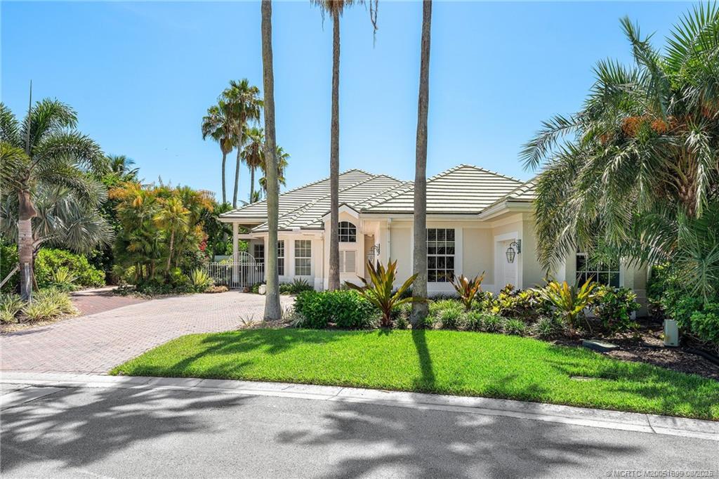 7000 Southeast Lakeview Terrace Stuart, FL 34996 - Photo 54 of 56 a front view of a house with a garden and palm trees