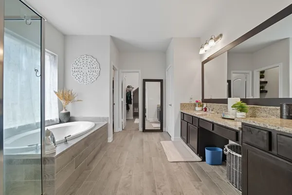 a large bathroom with a granite countertop double vanity sink a mirror and a shower