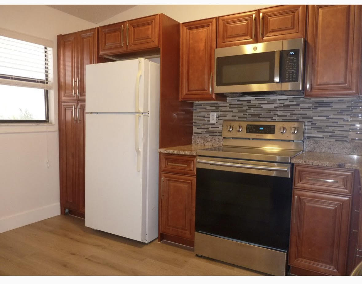 3130 Millwood Terrace, Unit 2120 Boca Raton, FL 33431 - Photo 7 of 15 a kitchen with stainless steel appliances granite countertop a refrigerator stove and microwave