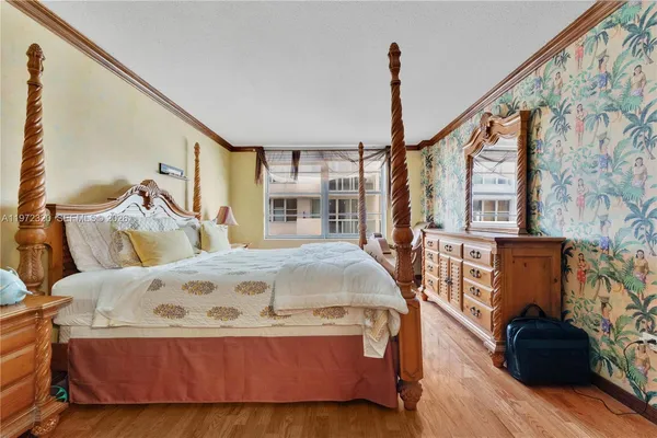a spacious bedroom with a bed and wooden floor