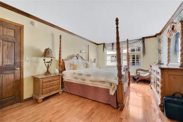 a spacious bedroom with a bed and wooden floor