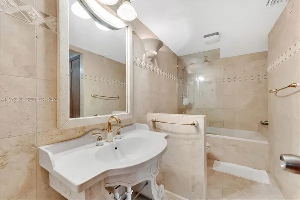 a bathroom with a sink a toilet a mirror and shower