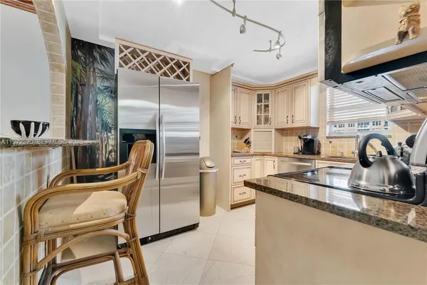 a kitchen with white cabinets and appliances