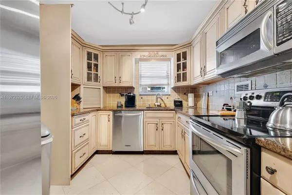 a kitchen with granite countertop a refrigerator and a sink