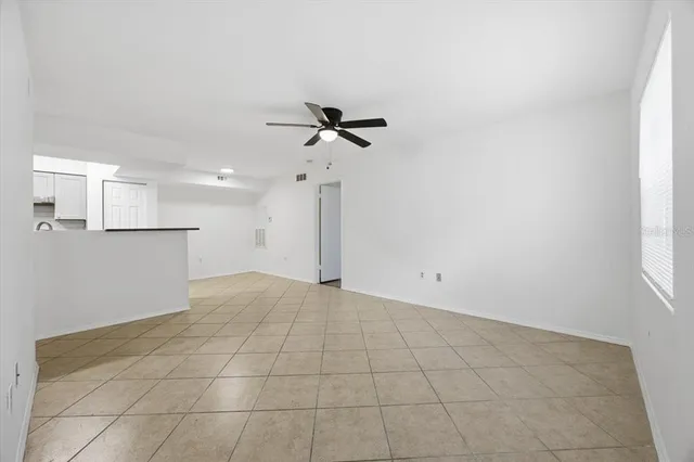 an empty room with a ceiling fan and a window