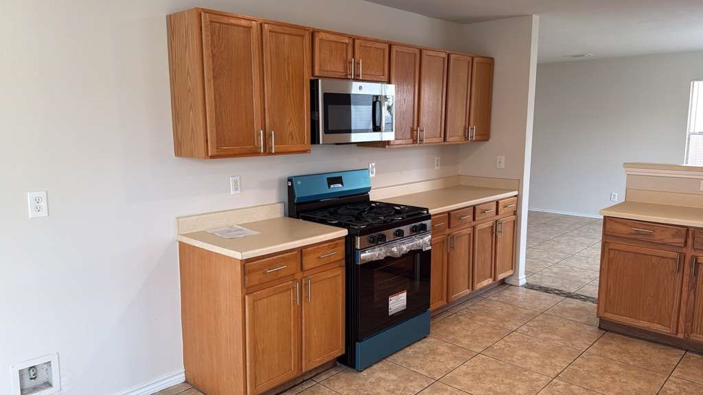 6622 Sutton Meadows Drive Houston, TX 77086 - Photo 11 of 45 a kitchen with stainless steel appliances granite countertop a stove and a microwave
