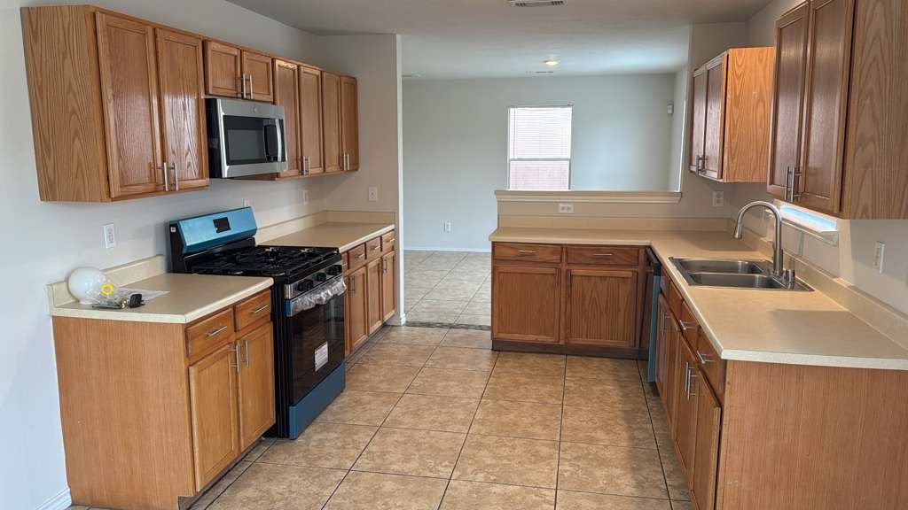 6622 Sutton Meadows Drive Houston, TX 77086 - Photo 9 of 45 a kitchen with a stove sink and microwave