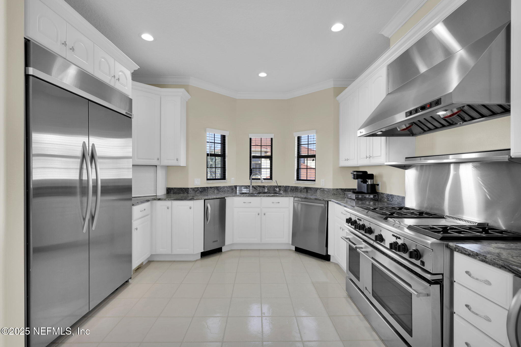 3713 Harbor Drive St. Augustine, FL 32084 - Photo 24 of 48 a kitchen with white cabinets and stainless steel appliances