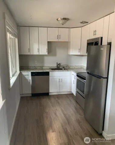 a kitchen with stainless steel appliances a refrigerator sink and cabinets