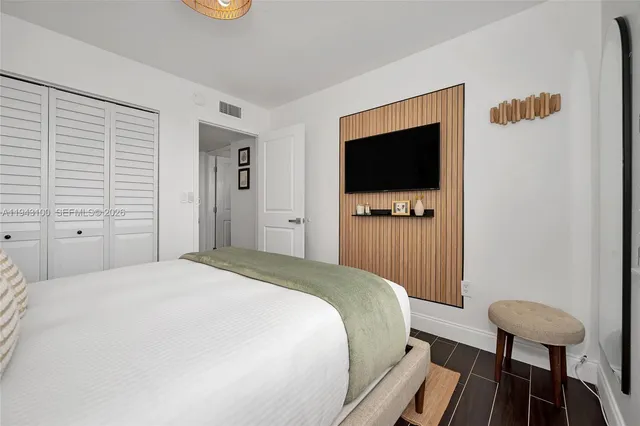 a bedroom with a bed and a flat screen tv