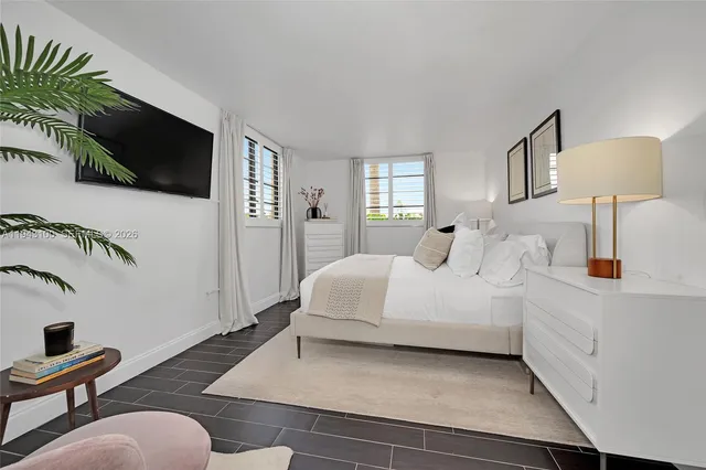 a spacious bedroom with a bed and a flat screen tv