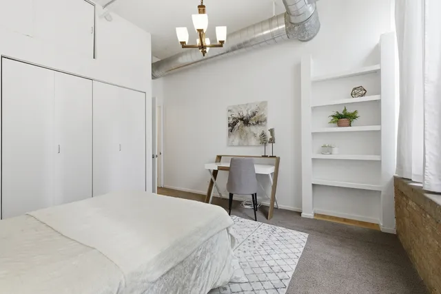 a bedroom with a bed and a chandelier