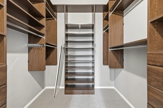 a view of walk in closet with empty racks